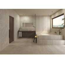 Ljust badrum med badkar, handfat och spegel för en avkopplande atmosfär