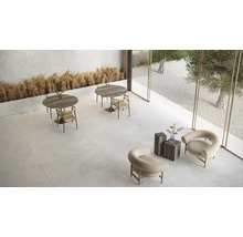 Ljust rum med bord, stolar och stenkakel