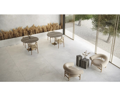 Ljust rum med bord, stolar och stenkakel