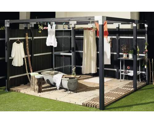 Exempel på trädgårdsdesign med badkar, träterrass och tvättlina under en pergola.