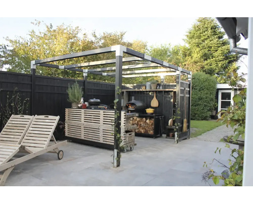 Trädgårdsscen med grillplats, pizzaugn och solstolar under en pergola