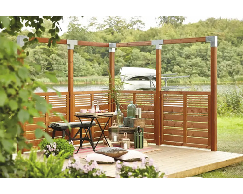 Terrass med träpergola, insynsskydd och dekorationer vid sjön