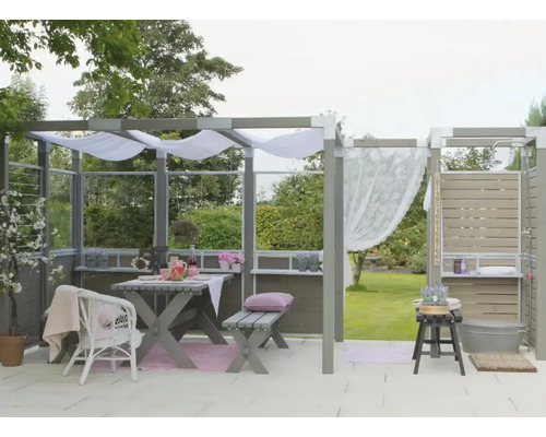 Terrass med trädgårdsmöbler, utomhusdusch och dekorativa textilier för en avkopplande utomhusatmosfär