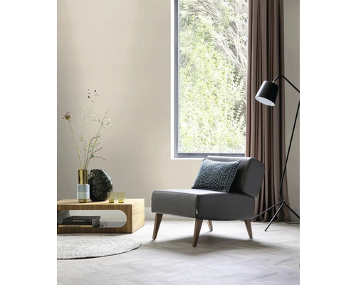 Vardagsrum med fåtölj, soffbord, golvlampa och fönster för en ljus och modern atmosfär