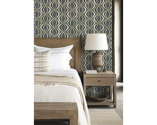 Sovrum med säng, sänglampa och mönstrad tapet