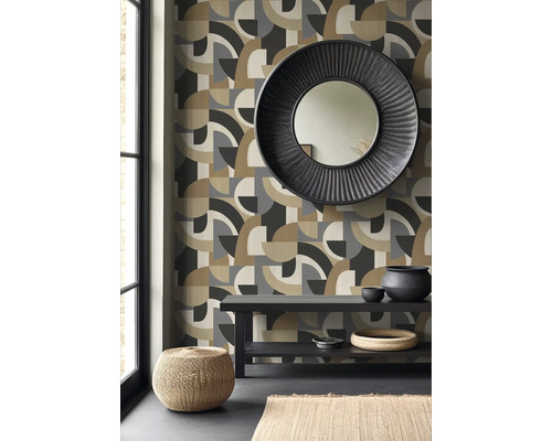 Vardagsrum med geometrisk tapet, rund spegel och dekorationer på ett bord