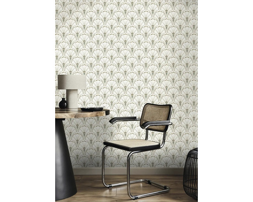 Scen med en väggtapet med ett fläktformat art déco-mönster, ett bord med en lampa och en stol