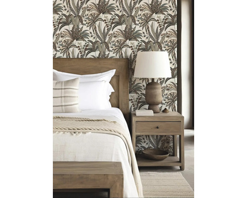 Sovrum med mönstrad tapet, träsäng och sängbord med lampa