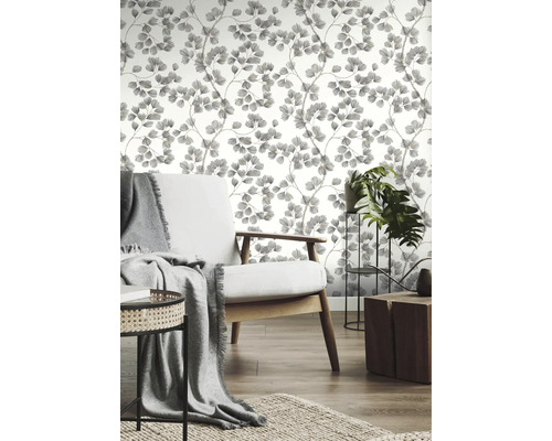 Vardagsrum med mönstrad tapet, fåtölj och krukväxter