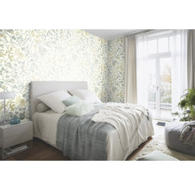 Sovrum med blommönstrad tapet, säng och överkast
