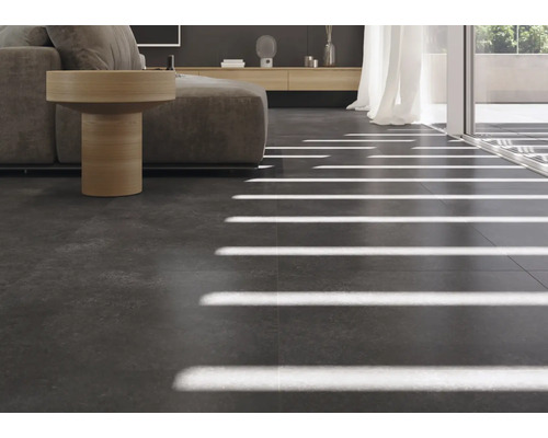 Modernt vardagsrum med mörka golvplattor och soffa