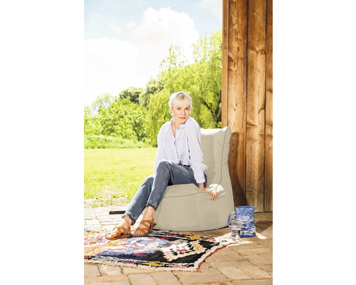 Kvinna sitter på en sittsäck i trädgården