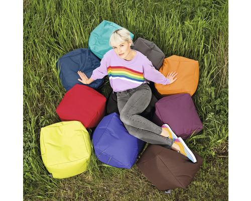 Kvinna sitter på en grupp sittkuber utomhus