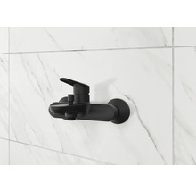 Svart duschblandare på en vit marmorvägg