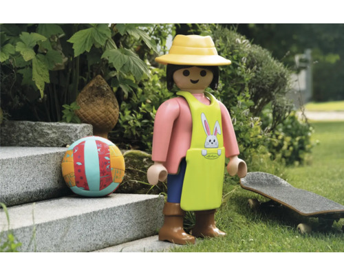 Scen med Playmobil-figur, boll och skateboard i trädgården