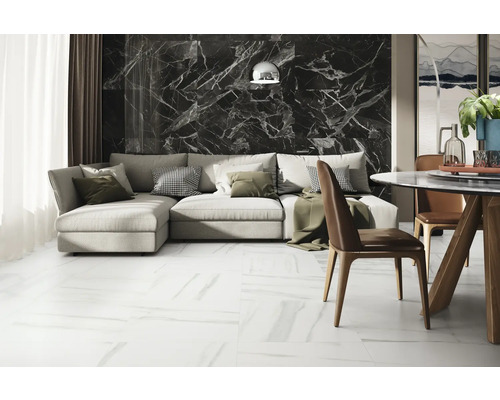 Modernt vardagsrum med soffa, matbord och kakel i marmorlook