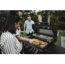 Grupp människor grillar räkor på en gasolgrill utomhus