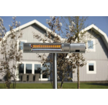 Sunred terrassvärmare med stativ utomhus framför ett hus.