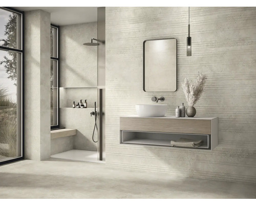 Ljust badrum med dusch, handfat, spegel och horisontellt strukturerade plattor.