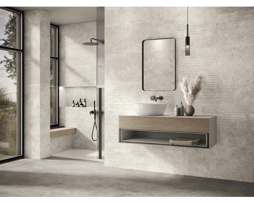 Modernt badrum med dusch, handfat, spegel och kakelvägg