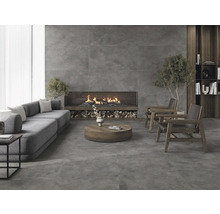 Vardagsrum med soffa, öppen spis och klinkergolv