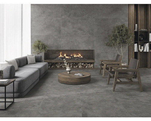 Vardagsrum med soffa, öppen spis och klinkergolv