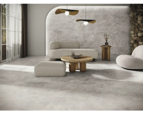 Ljust vardagsrum med golvplattor, soffa, fåtölj och soffbord