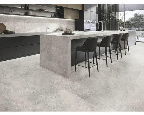Modernt kök med golvplattor i betonglook, köksö och barstolar.