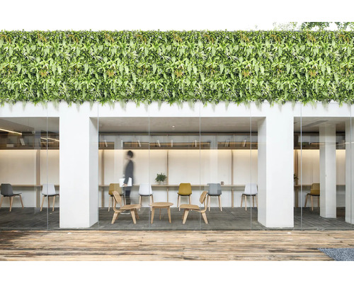 Kontorsbyggnad med konstgjord grön vägg, träterrass och moderna möbler.