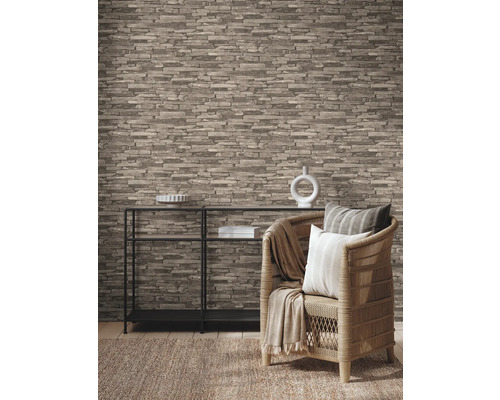 Vardagsrum med tapet i stenlook, hylla och rottingfåtölj