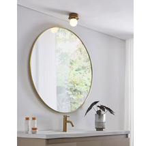 Modernt badrum med rund spegel, tvättställsblandare och taklampa