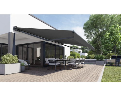 Terrass med markis, bord och stolar framför ett bostadshus