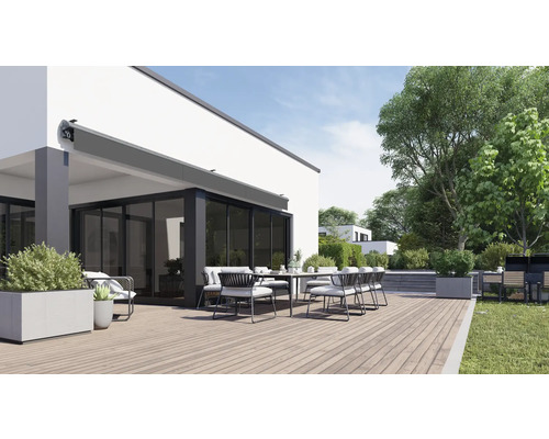 Terrass med markis, matbord och stolar framför ett bostadshus