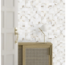 Vägg med mosaikplattor, byrå med rottingflätning och lampa