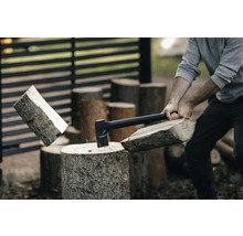 Man hugger ved med yxa på en huggkubbe