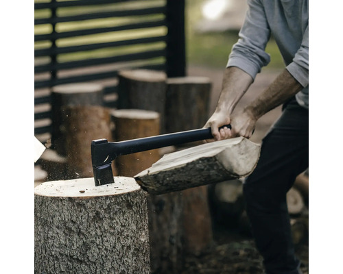 En person hugger ved med en yxa.