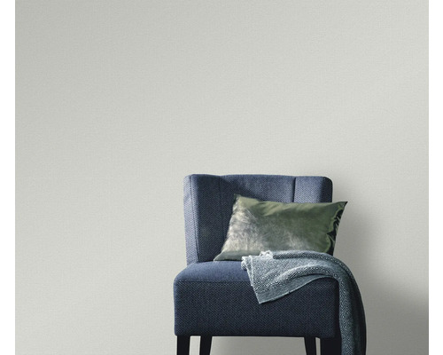 Vägg med textiltapet, stol, kudde och filt