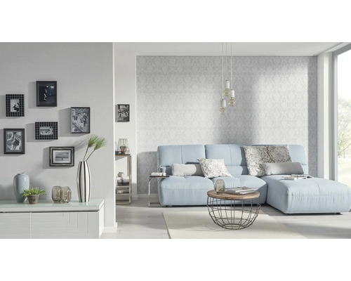 Vardagsrum med ljusblå soffa, soffbord och fotoramar på väggen.