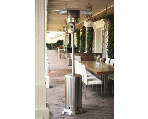 Terrassvärmare i stål på en terrass med bord och stolar