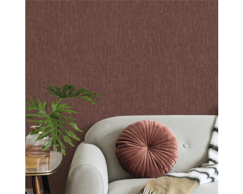 Vardagsrum med textiltapet, soffa, kudde och krukväxt