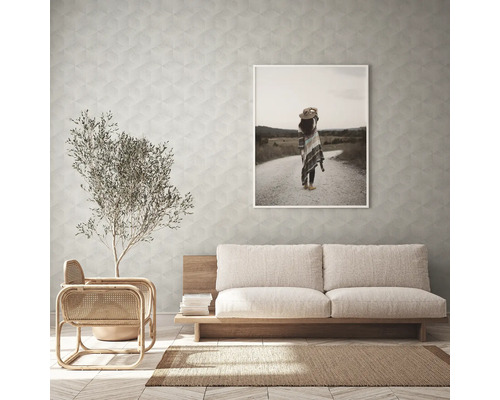 Vardagsrum med soffa, fåtölj, krukväxt, matta och inramad bild på väggen