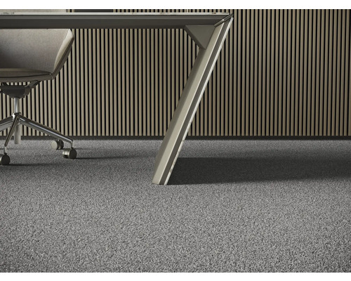 Detaljerad vy av en grå heltäckningsmatta i ett kontor med ett skrivbord och en kontorsstol.