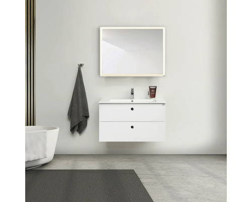 Badrum med vitt tvättställsskåp, spegel, handduk och badkar för en modern atmosfär