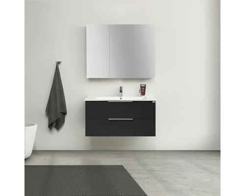 Badrum med tvättställsskåp, handfat, spegelskåp, handduk och matta