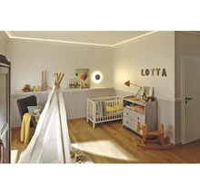 Babyrum med spjälsäng, lektält, byrå och trägolv