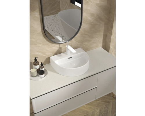 Badrumstvättställ med spegel och kran i ett ljust badrum