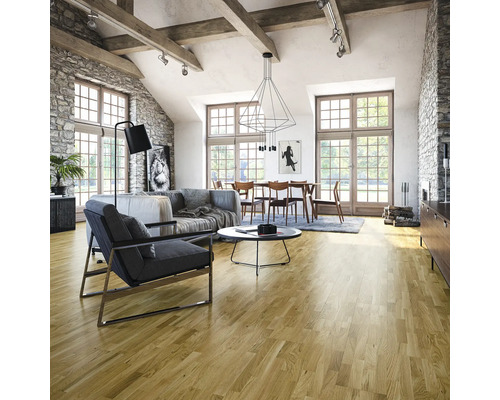 Ljust vardagsrum med trägolv, soffa, fåtölj och matbord under en modern hänglampa.