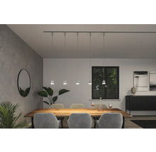 Matsal med matbord, stolar och skensystem med pendellampor