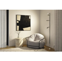 Vardagsrumsscen med fåtölj, golvlampa och konstverk på väggen