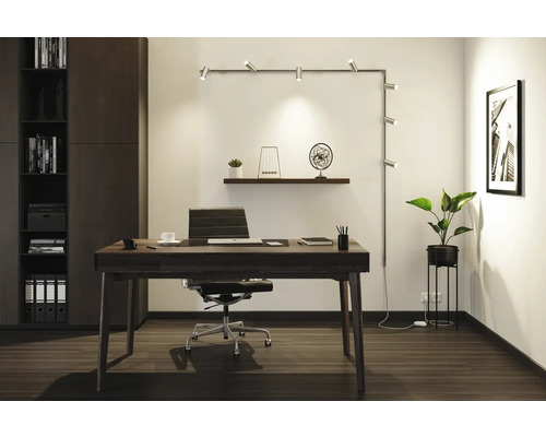 Kontor med skrivbord, kontorsstol, hyllsystem och belysning